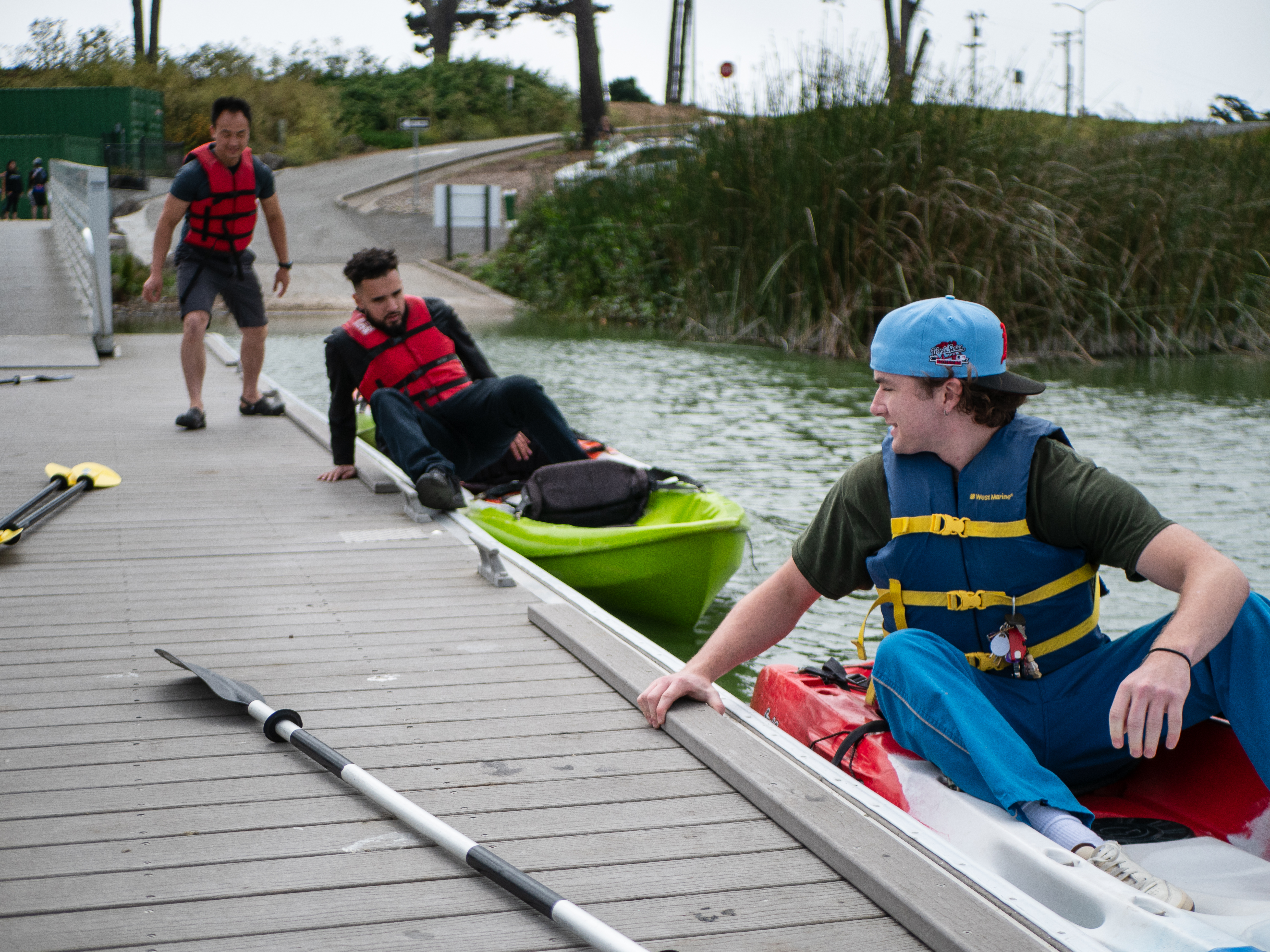 Participants climbing onto kayaks from the dock