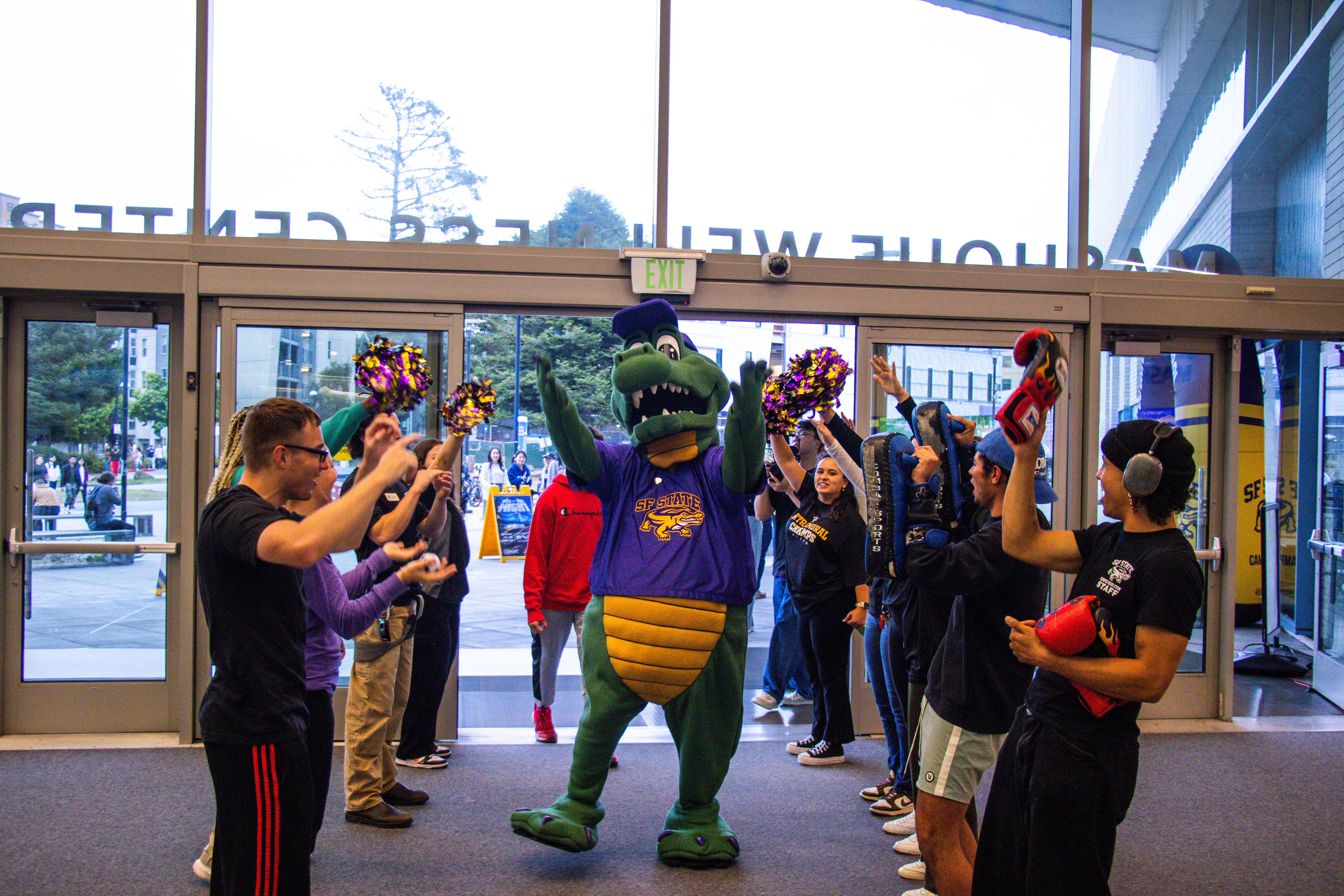 Alli the Gator Walking into MWC surrounded by clapping and cheering students