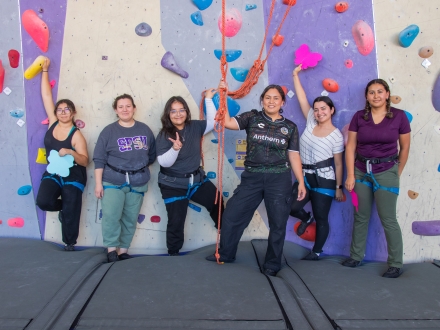 Group in front of Climbing Wall for Rise Beyond Borders event.